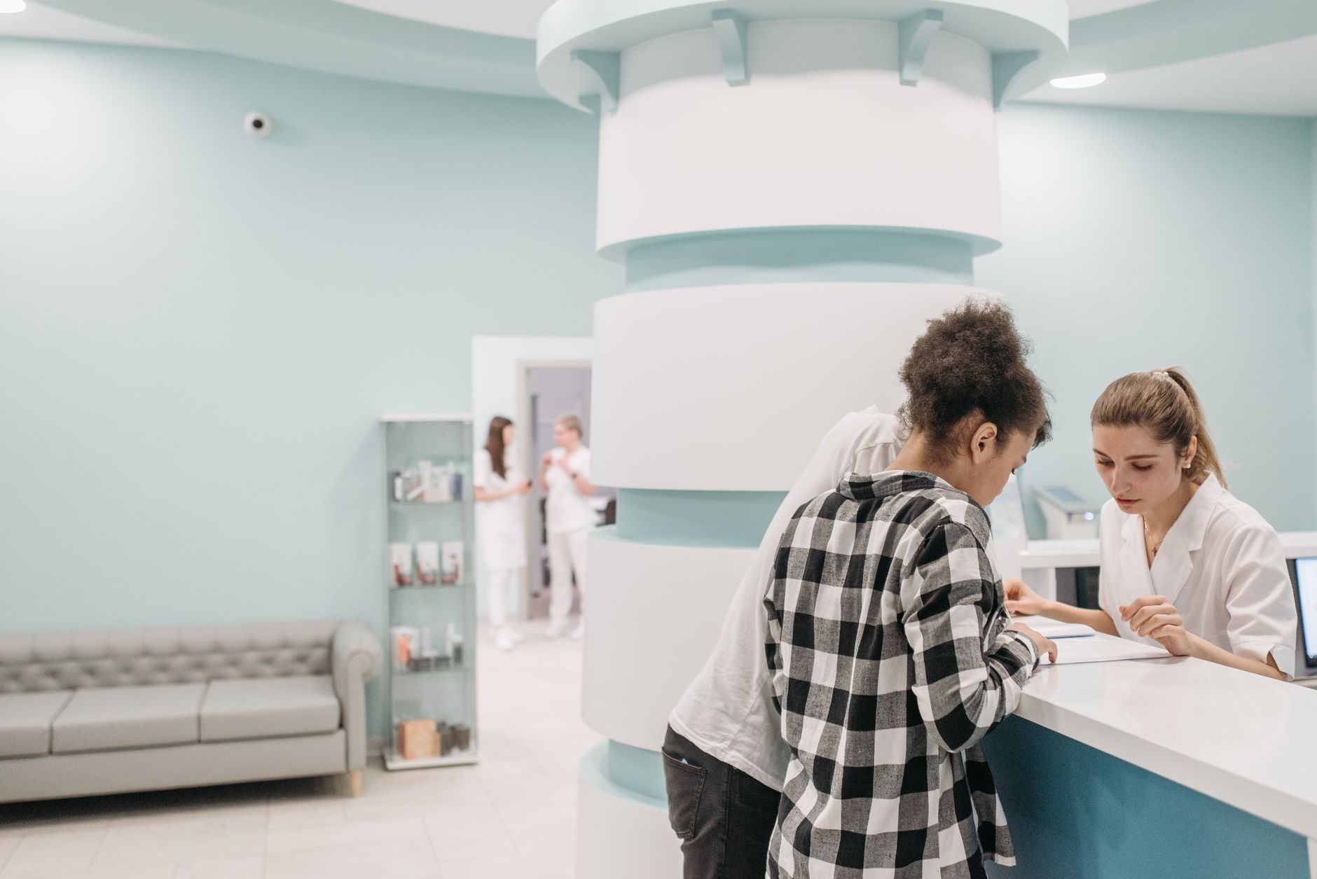 A patient being helped at a clinic reception desk